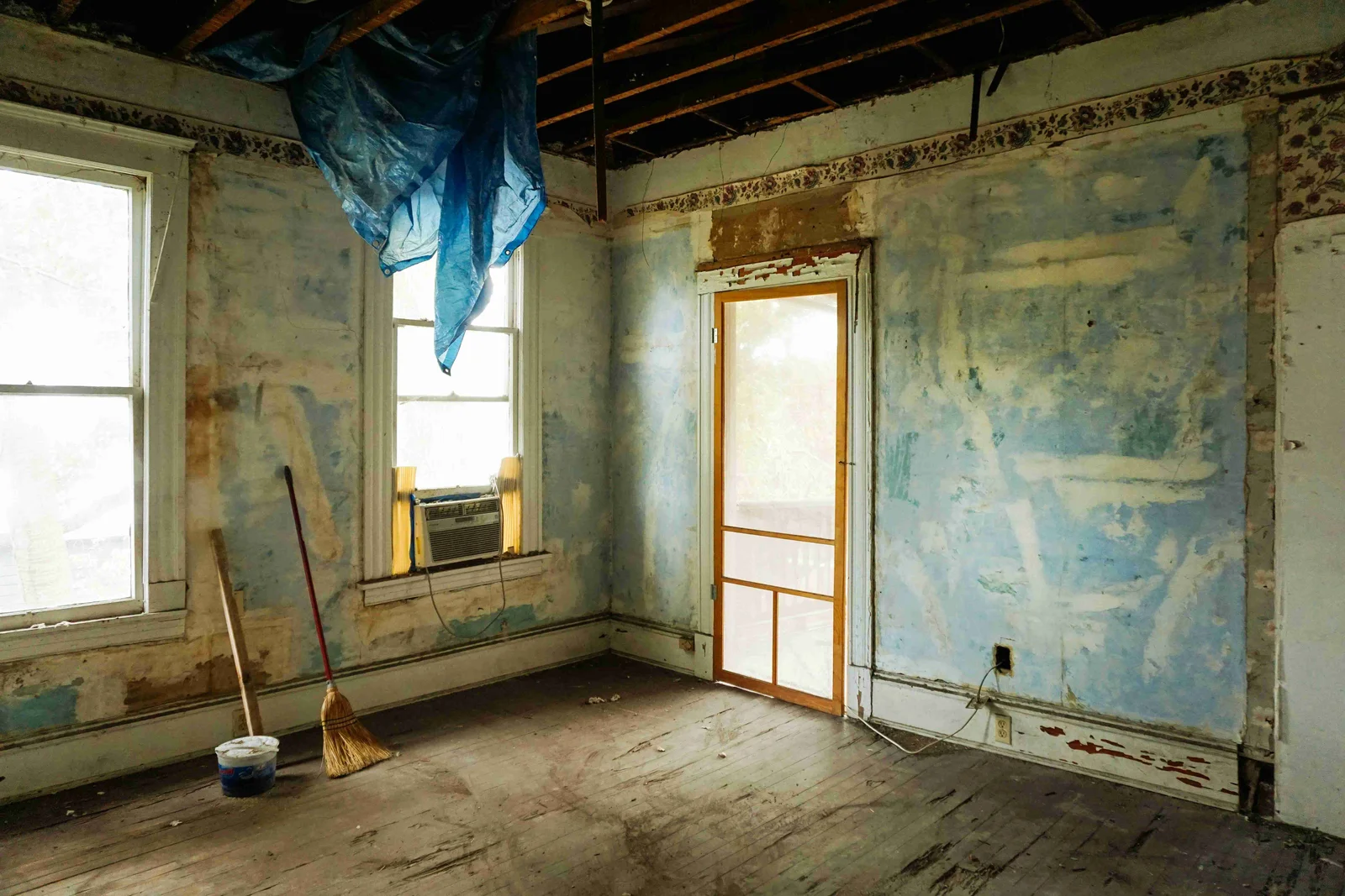 Intérieur d'un bâtiment en cours de démolition ou de rénovation, avec des murs dénudés et des matériaux de chantier